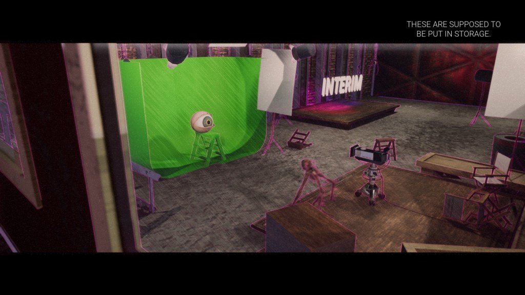 A walking eyeball creature is heading from the recording area to the green screen directly across from it. There is an eyeball on a green stepladder. The word "INTERIM" is hung by wires to the right of the green screen.